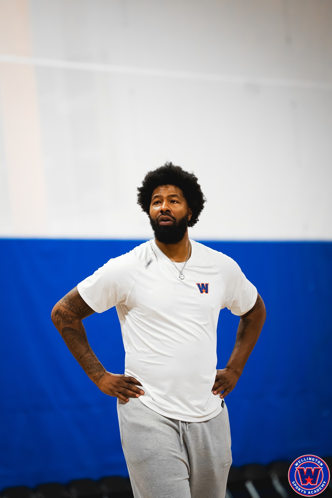 Portrait of WSA coach in white shirt, hands on hips, looking off to the side