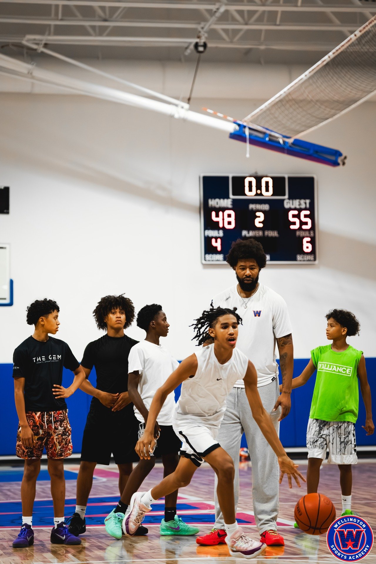 Player practicing a dribble move surrounded by teammates, scoreboard showing 48–55