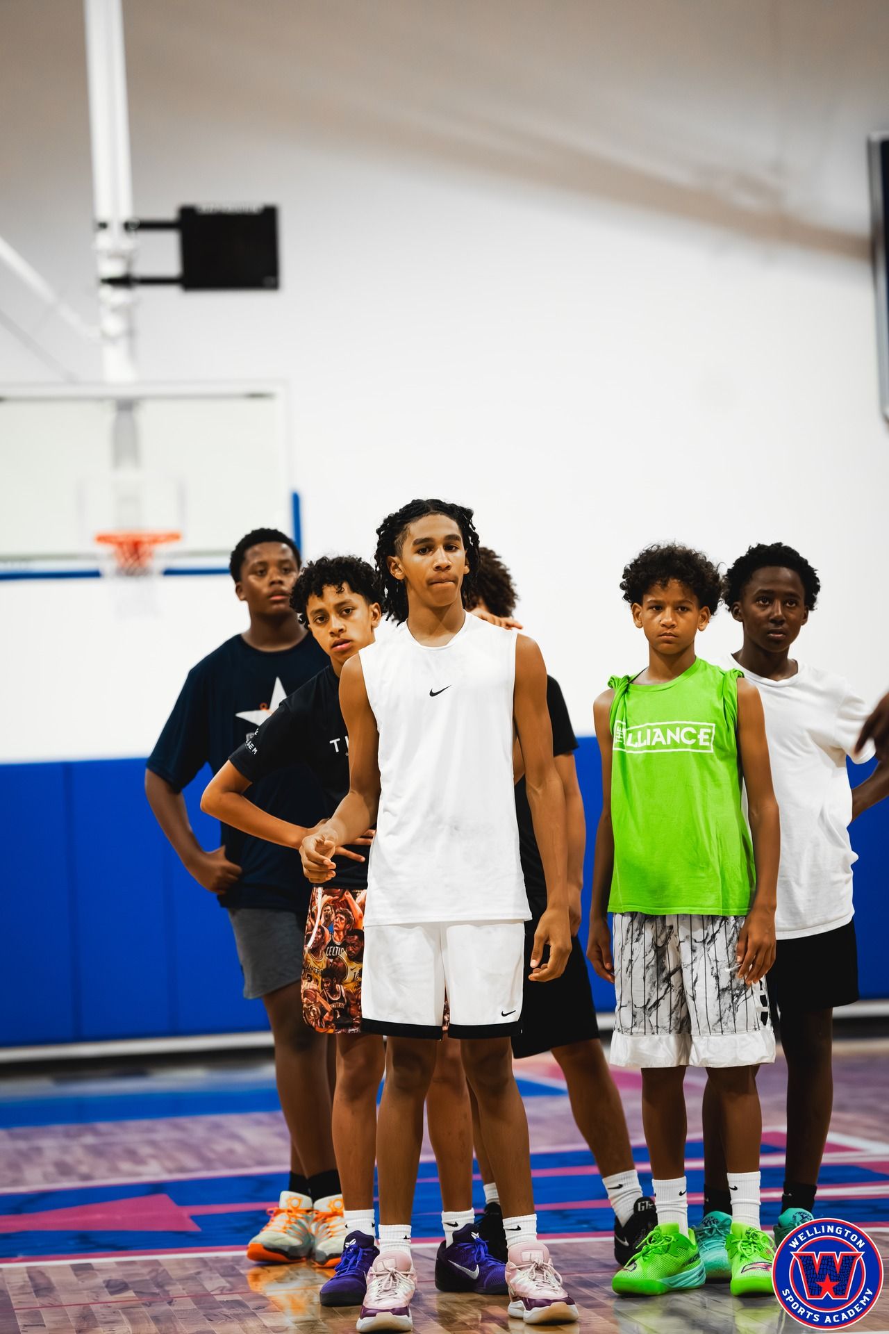 Group of five young players standing together watching during practice