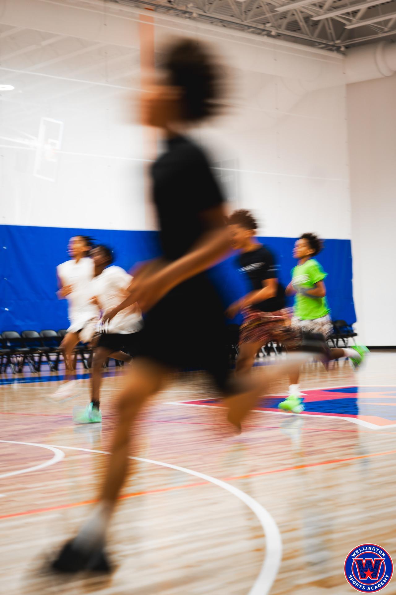 Motion-blurred players running court sprints during a conditioning drill