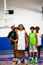Group of five young players standing together watching during practice